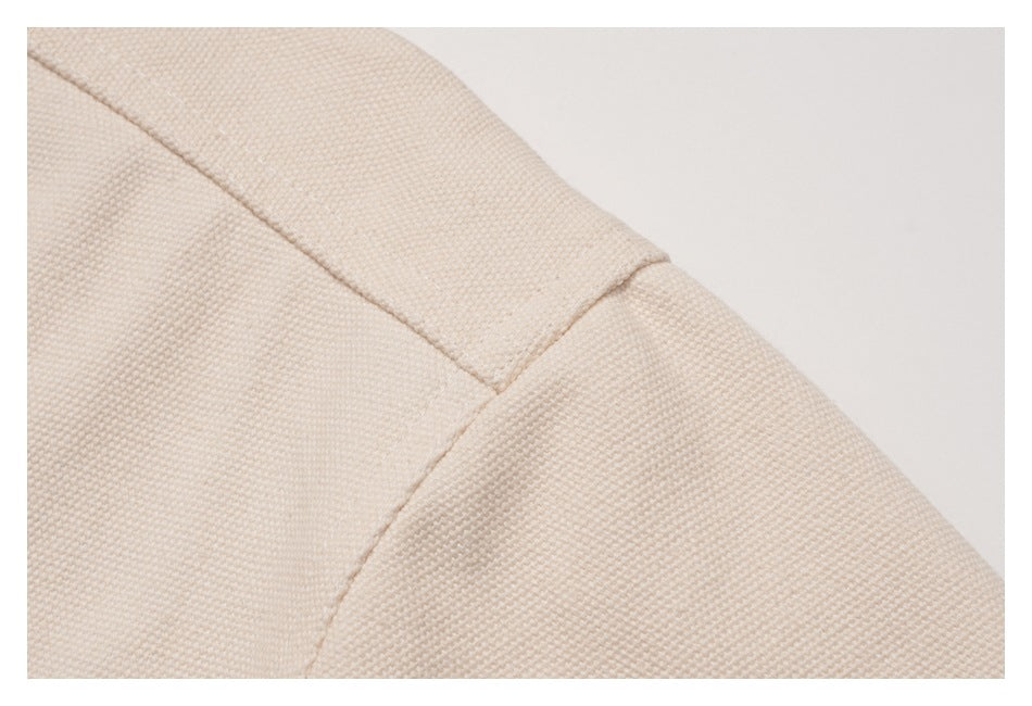 Close-up of the shoulder seam on a beige jacket.