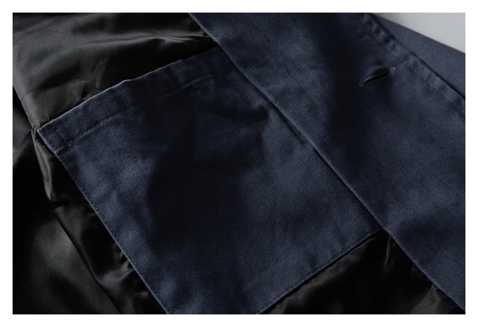 Close-up of a dark blue jacket pocket and front opening, showing the black lining inside.