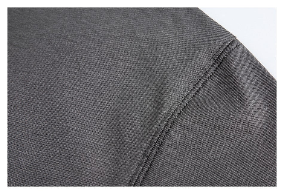 Close-up of a charcoal garment's shoulder seam and stitching.