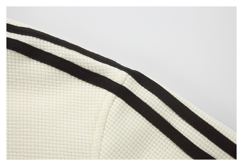 Close-up of cream textured fabric with a black stripe along a seam.