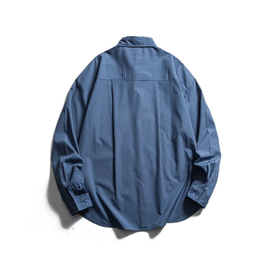 Back view of a blue plaid long-sleeve shirt with a yoke, center pleat, and button cuffs.