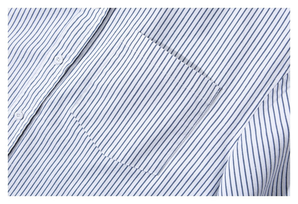 Close-up of a white shirt with narrow blue vertical stripes, showing a chest pocket and white buttons.