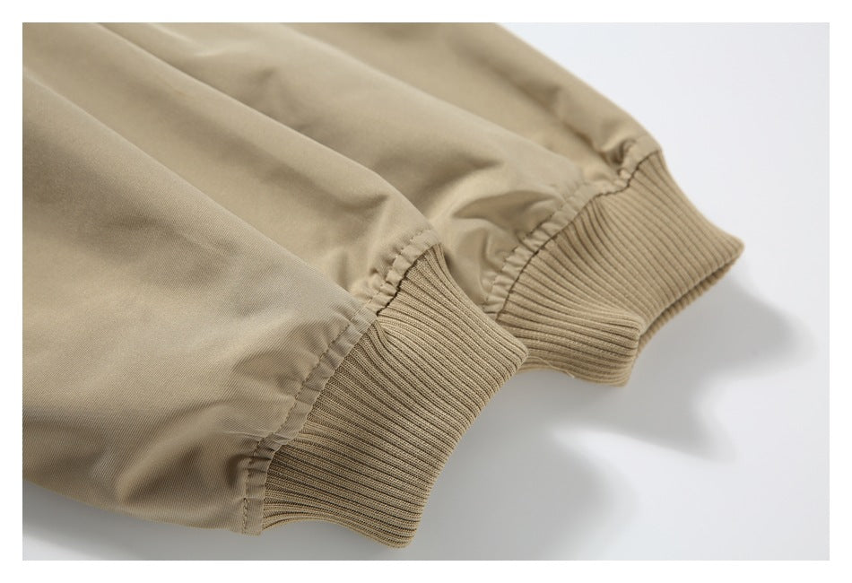 Close-up of two ribbed cuffs on a beige jacket.