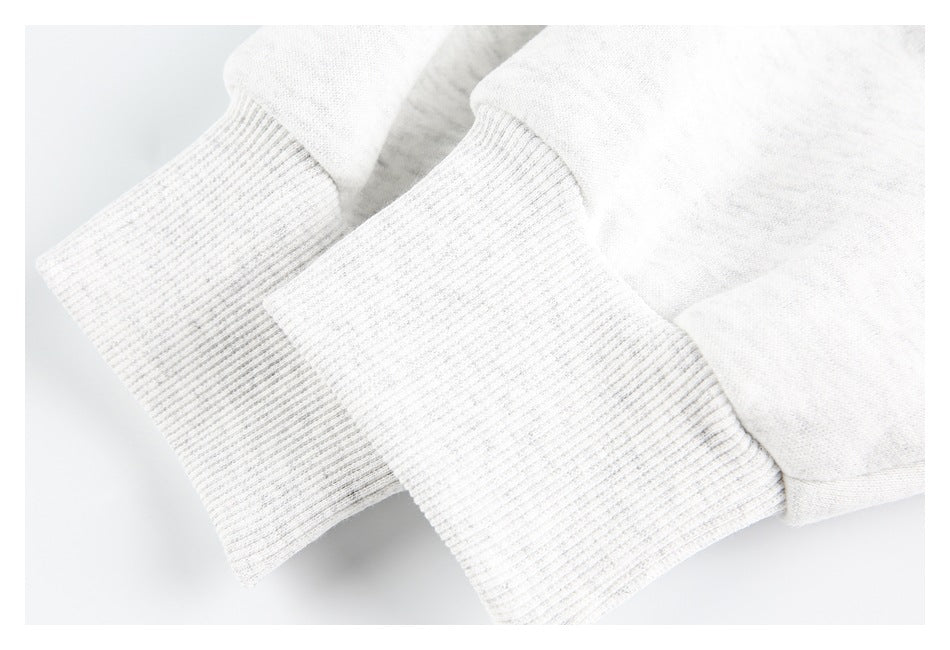 Close-up of two off-white ribbed sleeve cuffs.