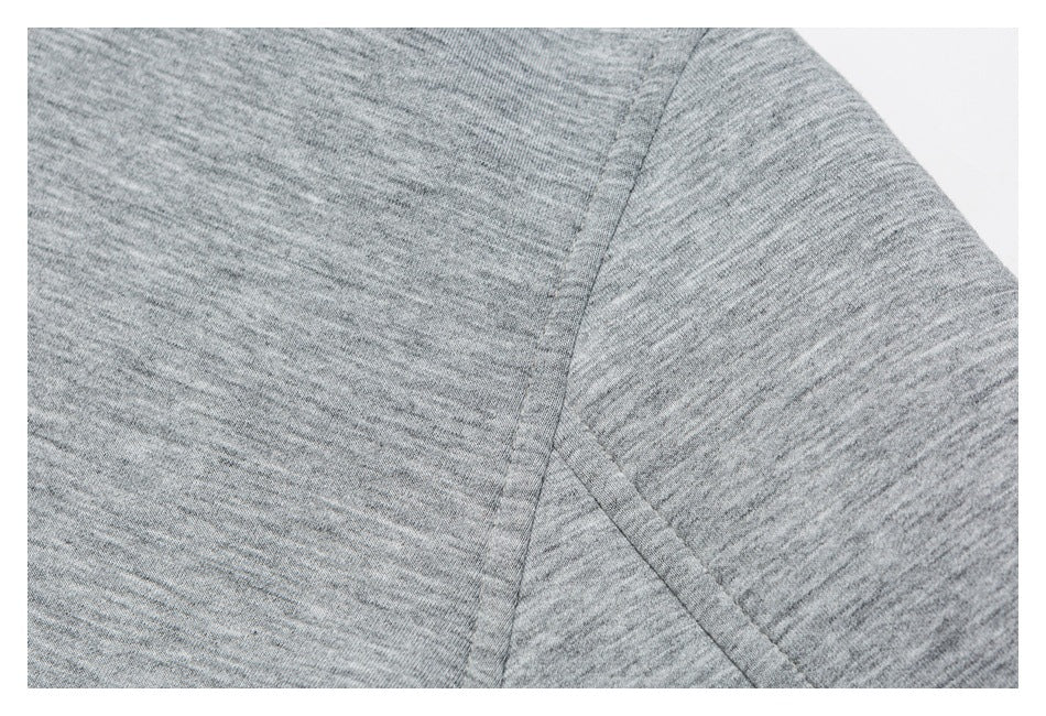 Close-up of a seam joining the sleeve and body of a heather gray garment.