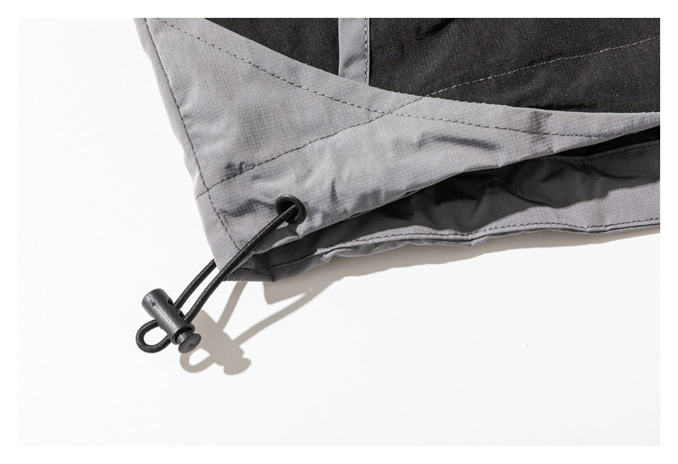 Gray and black garment hem with a black elastic drawcord and toggle.