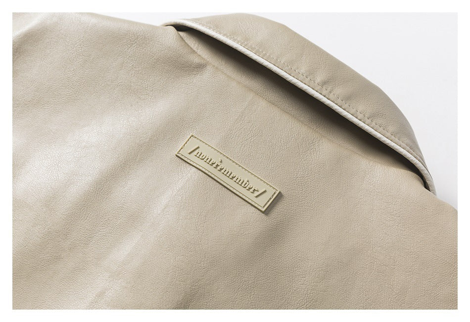 Close-up of a beige jacket collar and a small embossed rectangular label.