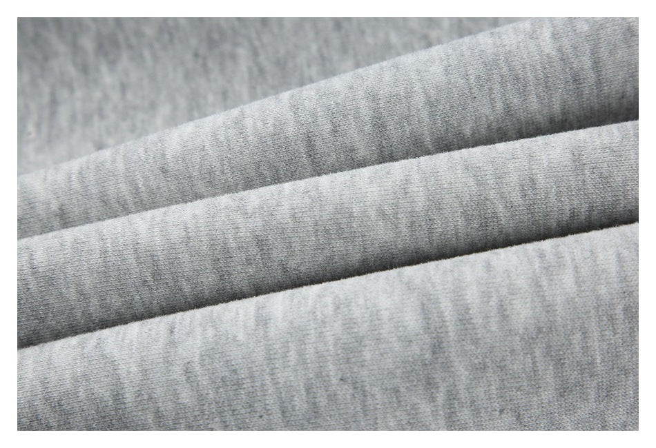 Close-up of light gray knit fabric arranged in soft folds.