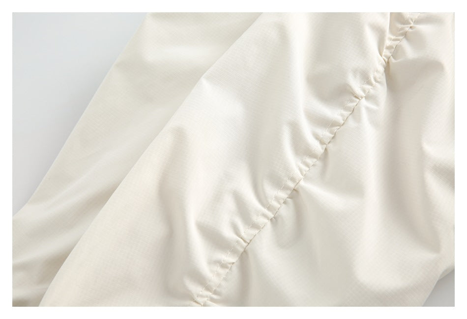 Close-up of the inside of an ivory garment, showing a stitched seam and smooth lining.