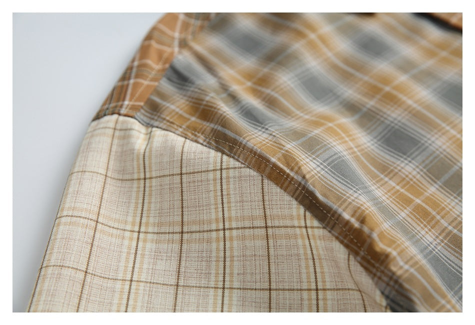 Close-up of plaid shirt fabric folded back to show the lighter checked reverse and stitched seam.