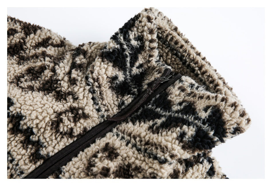 Close-up of a black zipper on plush beige, brown, and black patterned fleece.