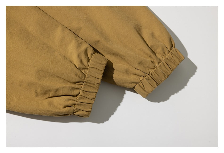 Close-up of mustard-brown sleeves with gathered elastic cuffs.