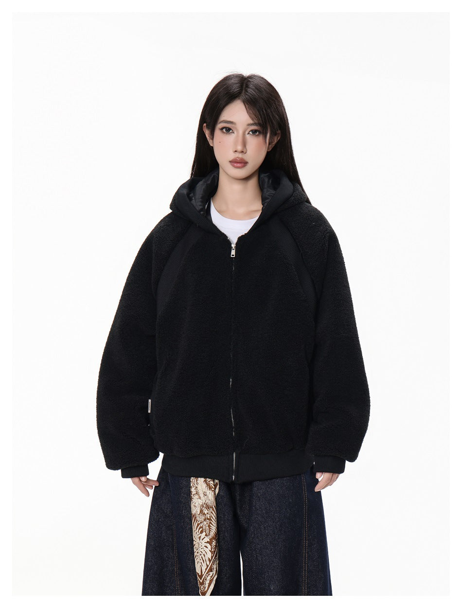 Front view of a model wearing a black hooded zip-up jacket with a relaxed fit and ribbed trim.