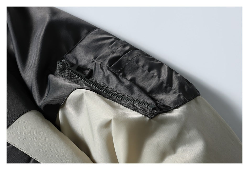 Close-up of the jacket's black sleeve zipper pocket and contrasting beige panel.