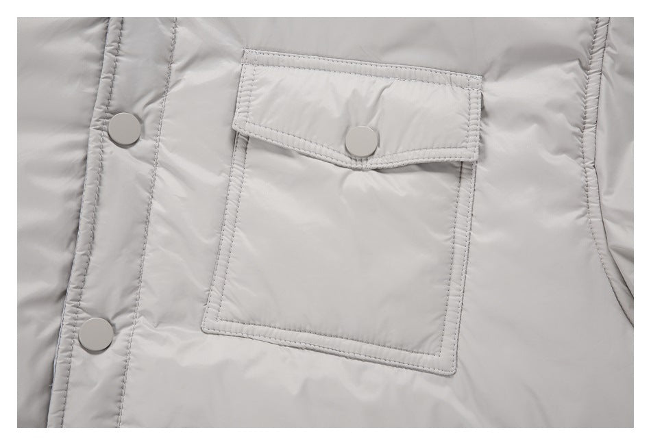 Close-up of a light gray jacket's flap chest pocket and snap-button front placket.
