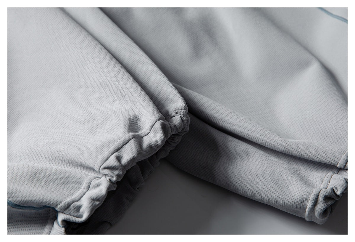Close-up of light gray mesh fabric with gathered seams and a finished edge.