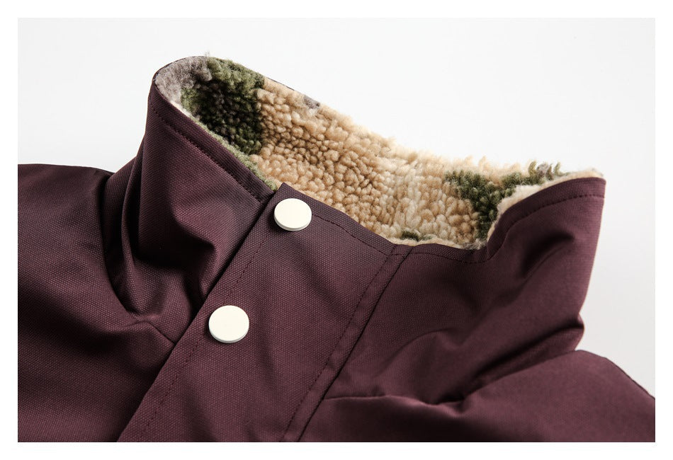 Close-up of a dark plum garment collar with two pale snaps and camouflage fleece lining.