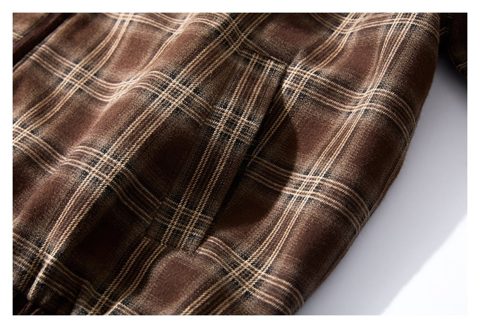 Close-up of brown plaid fabric and a vertical seam on the garment.