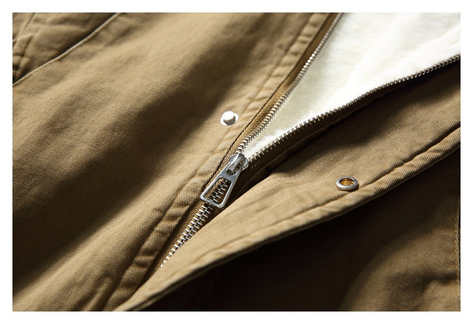 Close-up of the tan jacket's front zipper, metal pull, and snap-fastener placket.