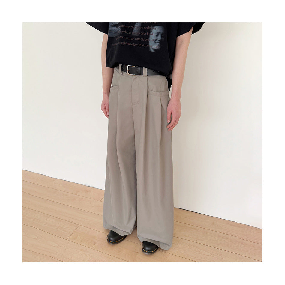 Model wearing loose, wide-leg gray trousers with front pleats and a black belt.