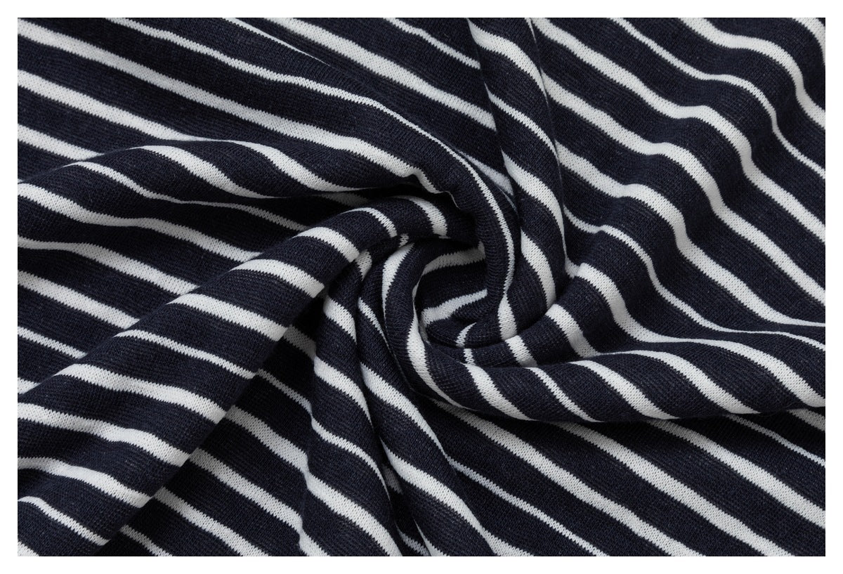 Close-up of dark navy knit fabric with narrow white stripes, loosely draped and folded.