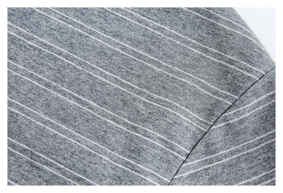 Close-up of a shoulder seam on gray heathered fabric with thin white stripes.