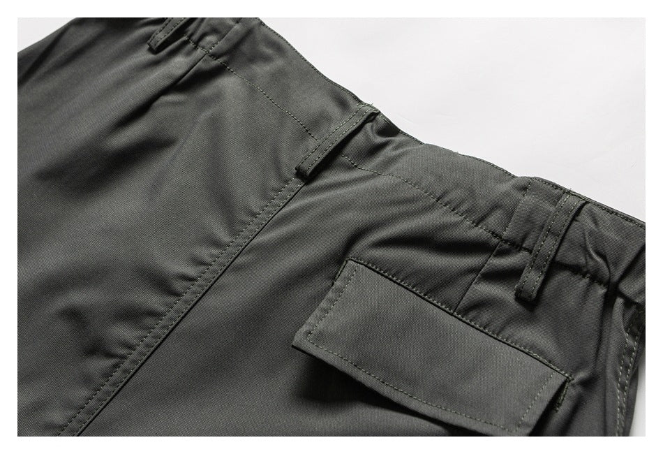 Close-up of the back of charcoal trousers, showing belt loops and a rectangular flap pocket.