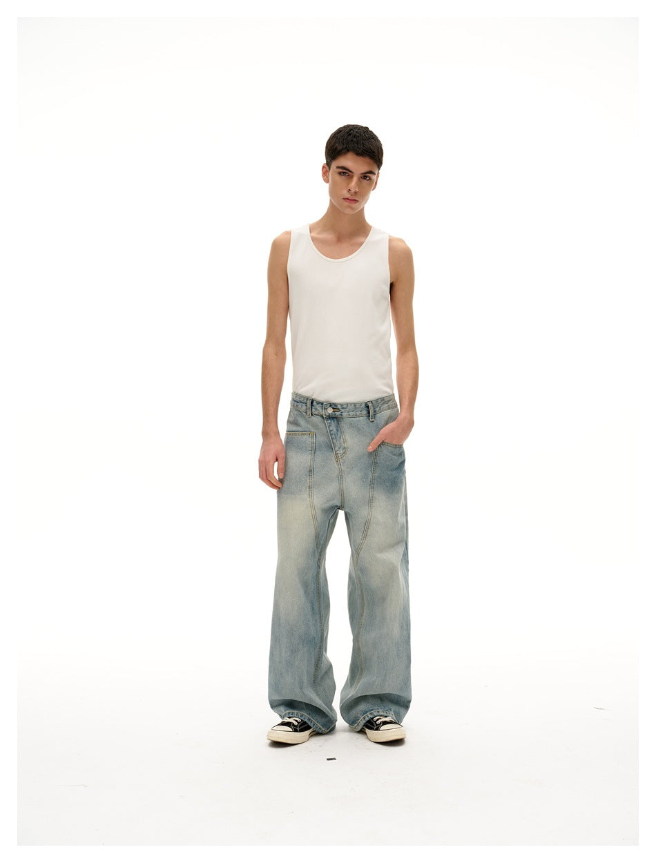 Model wearing washed blue wide-leg jeans with a white tank top and sneakers, one hand in the front pocket