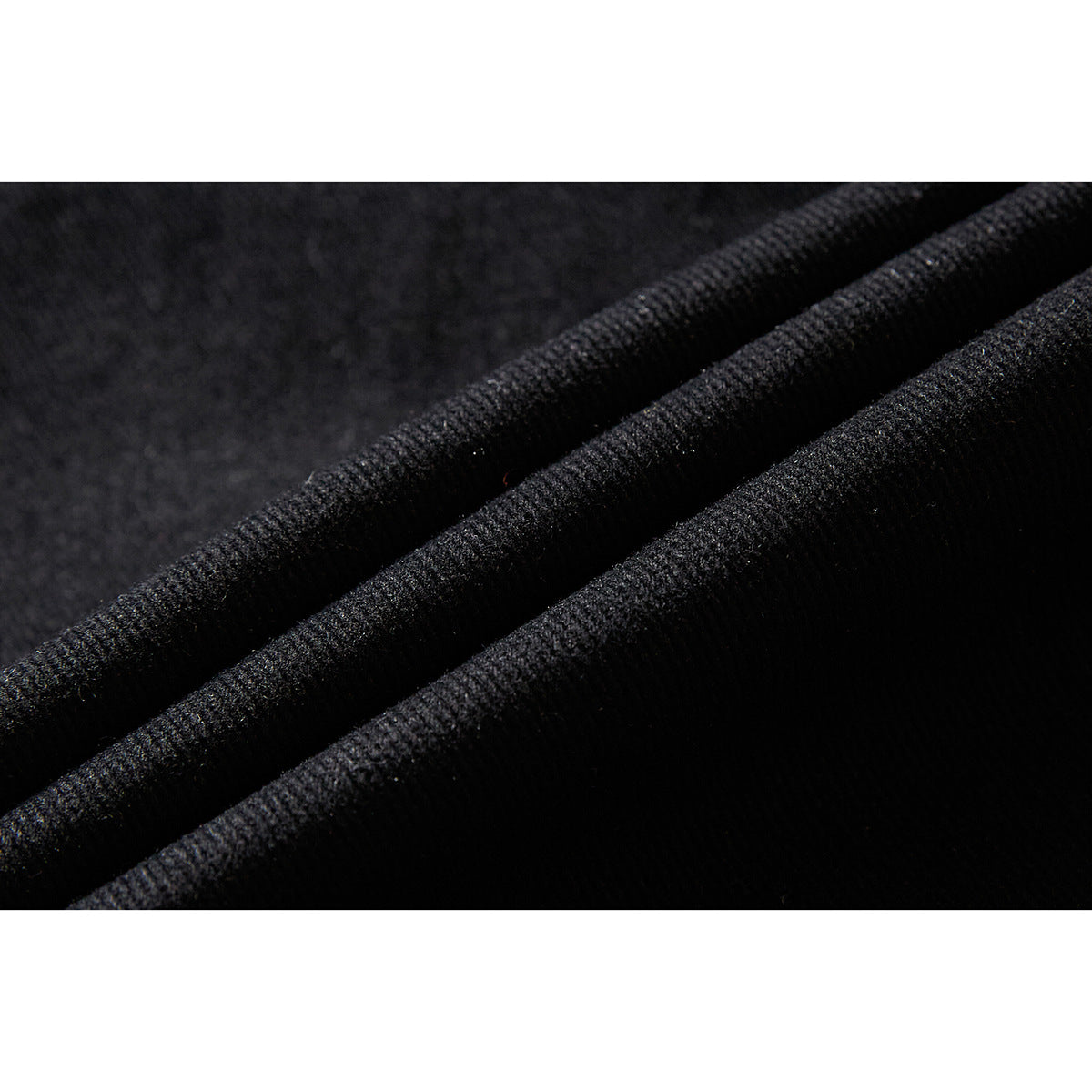 Macro view of the textured black fabric folded into soft ridges.