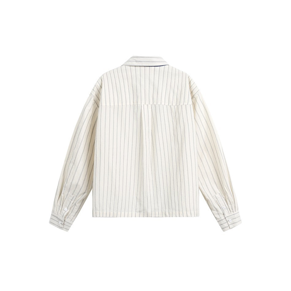 Back view of a beige shirt with thin vertical stripes, a back yoke, and long button-cuff sleeves.