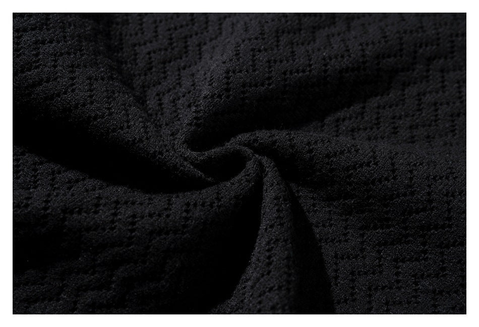Close-up of black textured knit fabric gathered into soft folds.