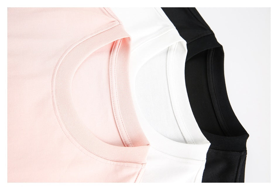 Close-up of overlapping pale pink, white, and black T-shirt crew necklines.