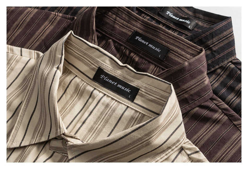 Close-up of the collars and neck labels on cream, brown, and dark striped shirts.