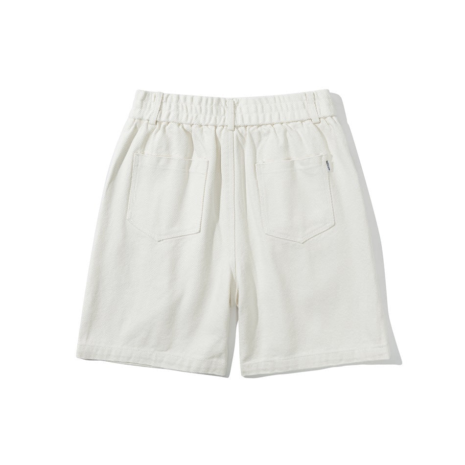 Back view of ivory shorts with an elastic waistband and two patch pockets.