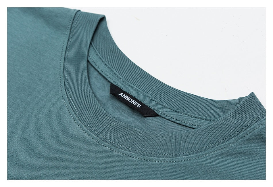 Close-up of the teal T-shirt's ribbed crew neck, stitching, and black inner brand label.