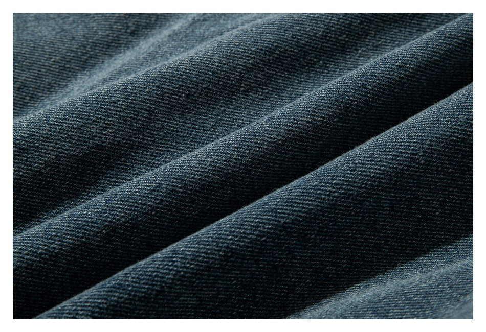 Extreme close-up of the dark blue-gray denim weave and fabric folds.