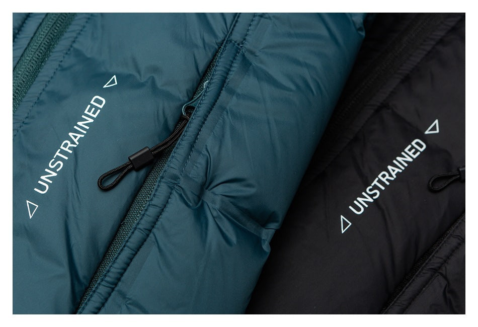 Close-up of teal and black padded jackets, showing white UNSTRAINED prints and black zipper pulls.