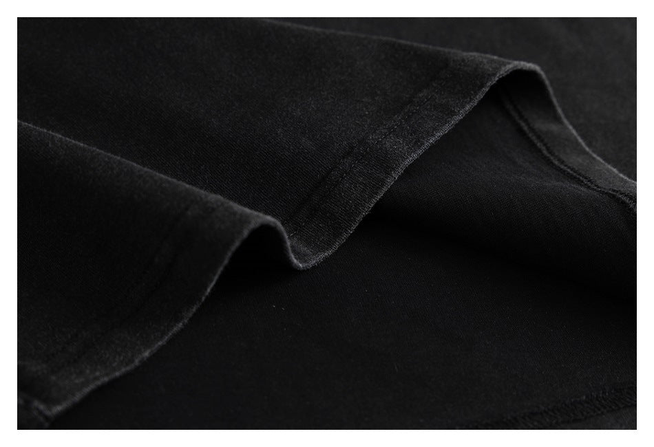 Close-up of black garment fabric folded to show a stitched edge.
