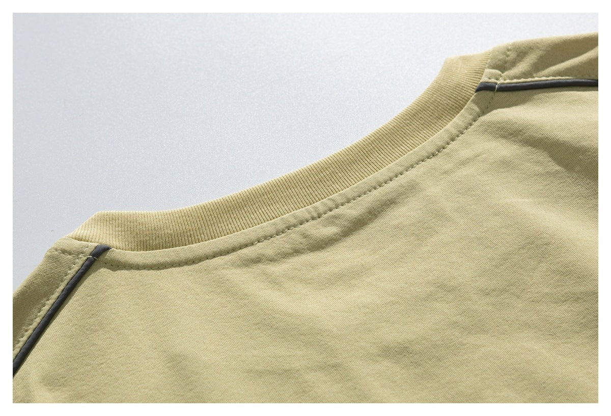 Close-up of the pale olive T-shirt's back neckline and shoulder seams with dark contrast piping.