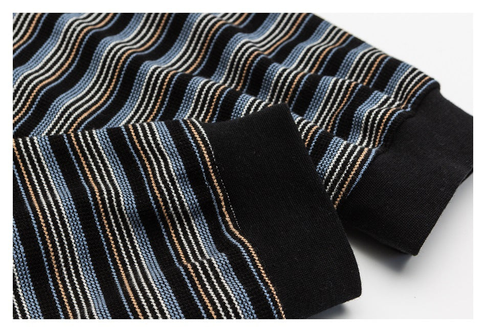 Close-up of a black ribbed cuff and striped sleeve in blue, cream, and brown.