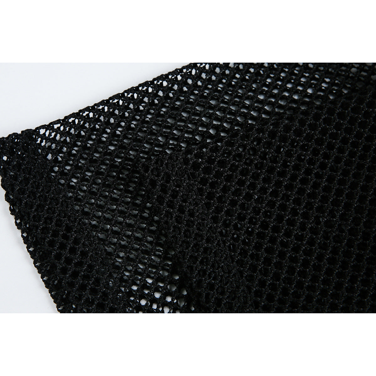 Close-up of black open-knit fabric with a denser stitched section and visible mesh openings.