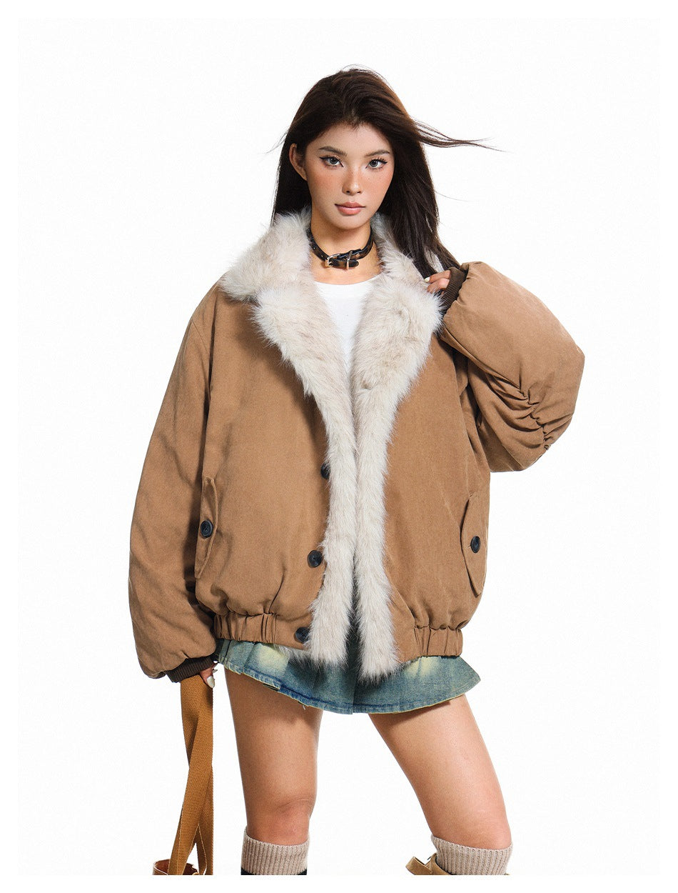 Model wearing khaki jacket with large fur-like collar over a white top and denim mini skirt