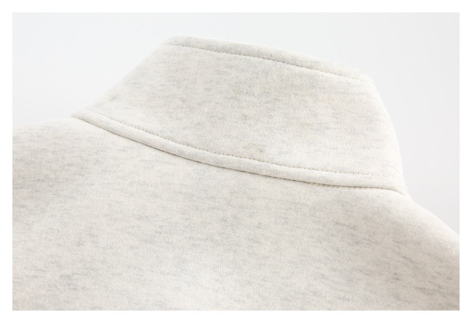 Close-up of an ivory heather sweatshirt collar with a curved stitched seam.