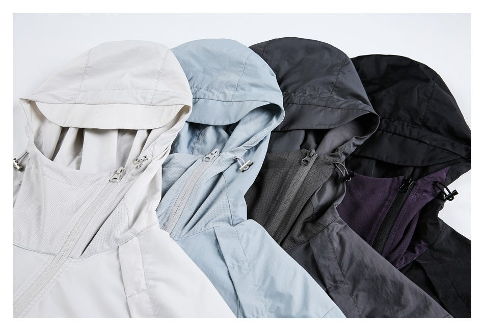 Close view of four hooded jackets in white, pale blue, dark gray, and black, showing zippers and hood details.