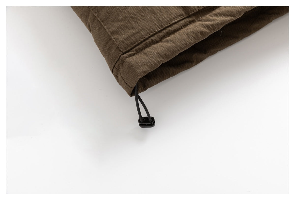 Close-up of the brown jacket hem with a black drawcord and toggle.