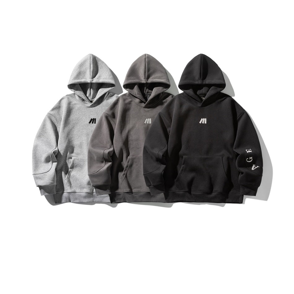 Three hoodies displayed together in light gray, charcoal gray, and black, each with a front pocket and small chest emblem.