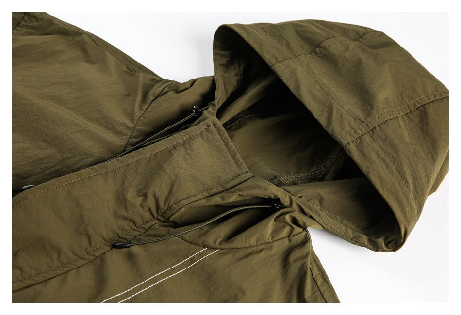Close-up of an olive hooded jacket showing the hood, drawcords, and contrasting seam stitching.