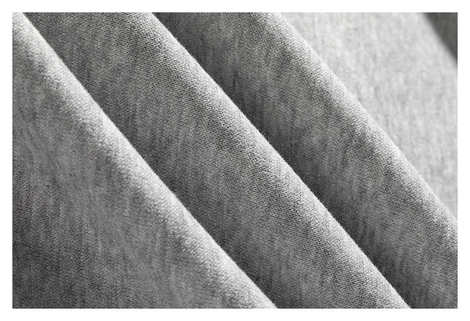 Extreme close-up of the soft-looking surface and folds of gray sweatshirt fabric.