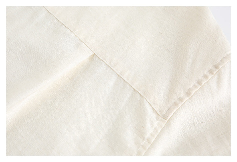 Close-up of overlapping stitched panels on an ivory shirt.
