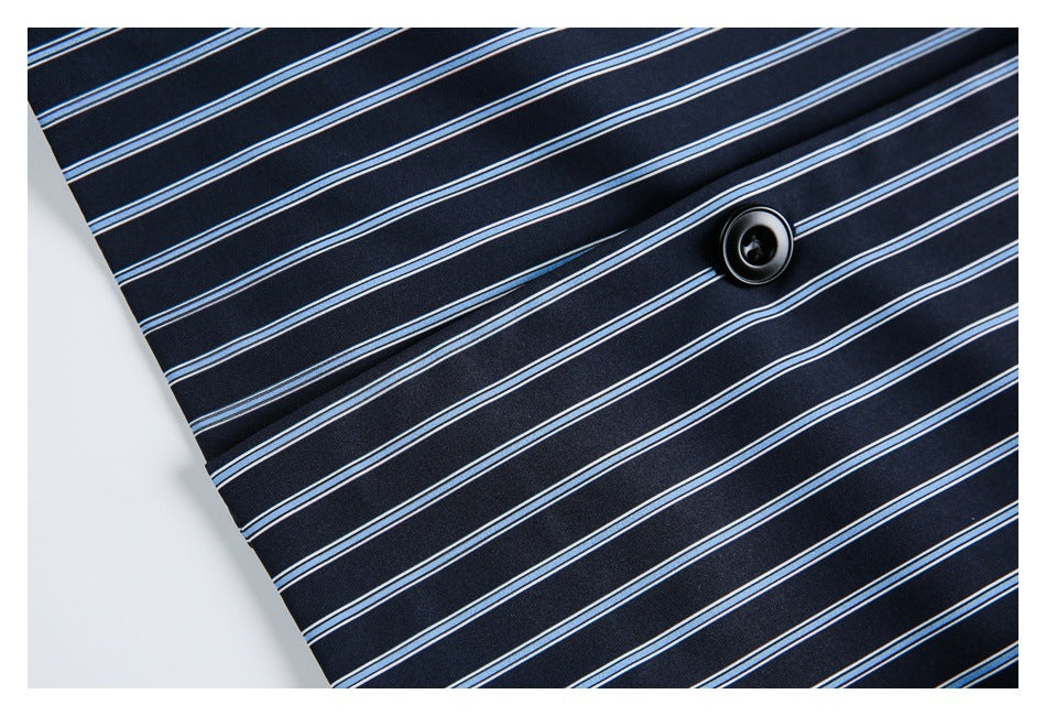 Close-up of a black button on navy fabric patterned with thin blue and white stripes.